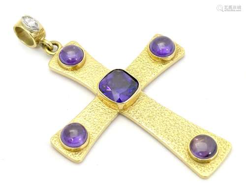 A large 18ct gold pendant of cross / crucifix form set with central facet cut purple stone and