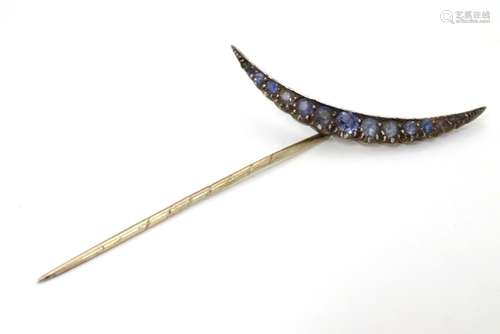 A late 19thC / early 20thC stick pin set with graduated pale sapphires? stones to top in a