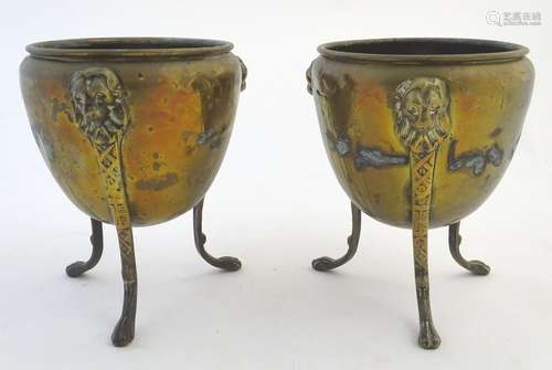 A pair of brass planters / jardinieres with lion mask decoration, raised on three legs terminating