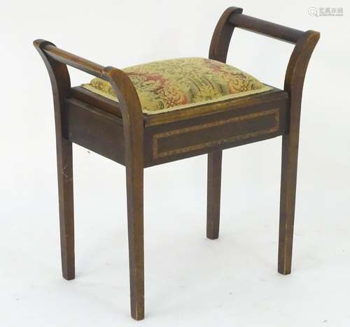 An early 20thC beech piano stool with scrolled supports, upholstered top and lifting lid, the