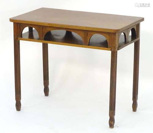 A late 19thC / early 20thC side table with a rectangular top above an arched frieze and raised on