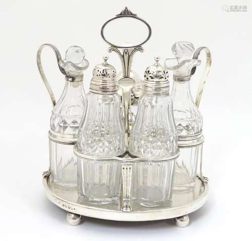 A Geo III silver cruet stand hallmarked London 1806 with 5 cut glass cruet bottles. The whole