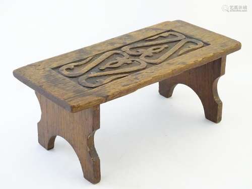 An early 20thC oak stool with a panelled top and shaped legs. 14 1/2