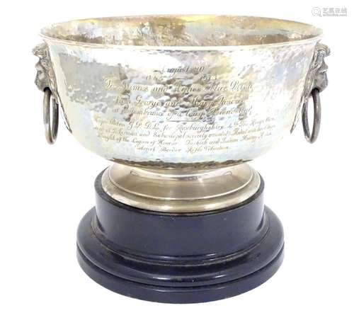 A large pedestal trophy / presentation bowl with hammered decoration, twin lion masks and ring