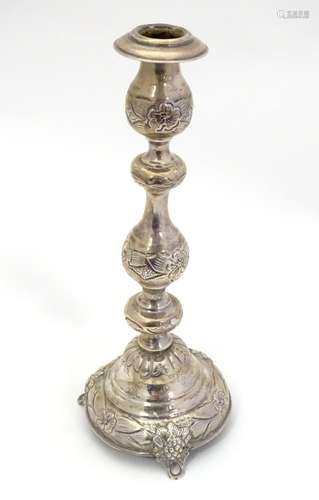 A silver candlestick with floral and fruiting vine decoration. Hallmarked London 1916 maker