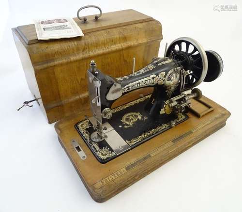 An early 20thC portable sewing machine by Frister and Rossman, walnut base and case, 19