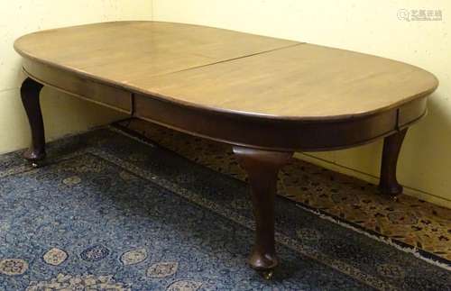 An early 20thC oak dining table with an oval shaped moulded top above large cabriole legs