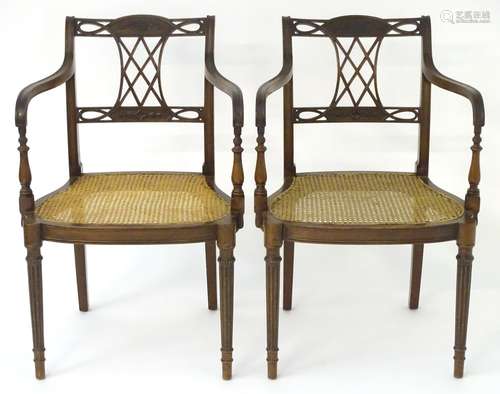 A pair of early 20thC mahogany open armchairs with caned seats, pierced and carved top rail and back