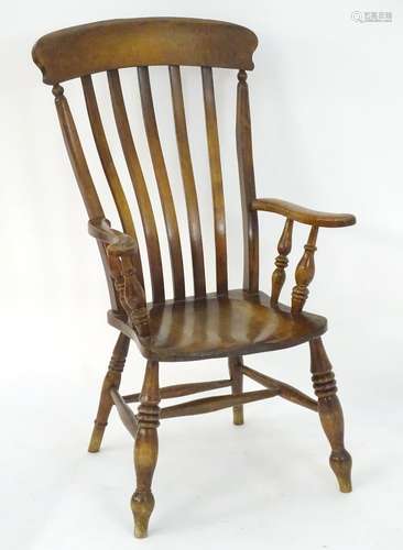 A late 19thC lathe back Windsor open arm chair with scroll arms, turned supports and raised on