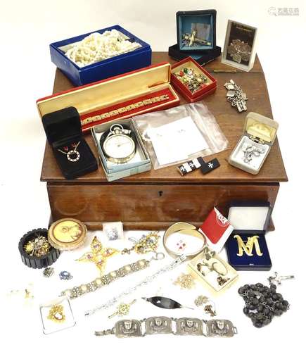 An early 20thC wooden writing box with slop top containing assorted items of costume jewellery