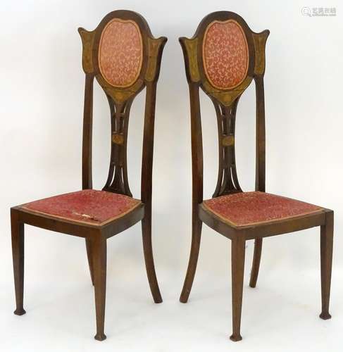 A pair of early 20thC Art Nouveau chairs with shaped and upholstered backrests, pierced back