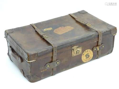 A late 19thC leather travelling trunk flanked by carrying handles. 34