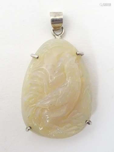 An Oriental carved jade pendant with cockerel decoration in a silver mount. Approx 2