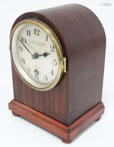 A stained mahogany arch-cased mantel clock having a 4 1/2