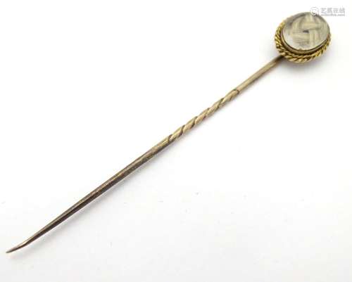 Mourning / memorial jewellery : A 19thC gilt metal stick pin surmounted by a locket containing