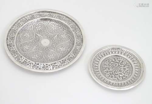 Two white metal dishes with floral and foliate decoration. The largest 6