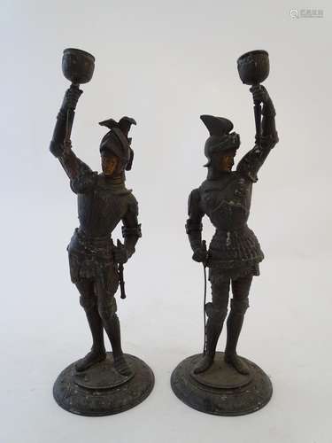 A pair of early-20thC figural candlesticks formed as French 16thC Knights, holding torches aloft