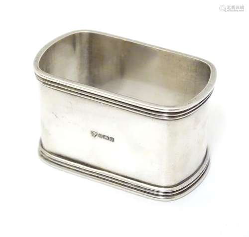 A silver napkin ring of rectangular form, hallmarked Sheffield 1996, maker C. J. Vander Ltd.