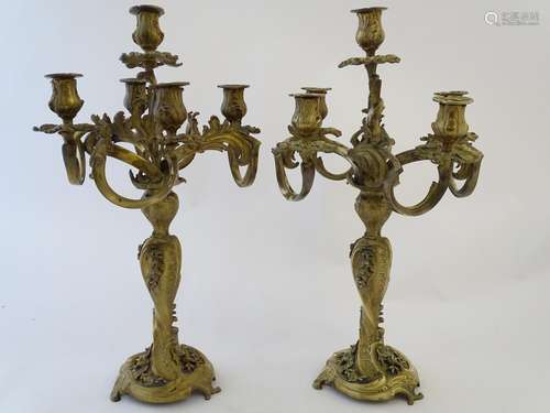 A pair of late 19thC cast brass and gilt candelabra, decorated in the rococco style with heavy