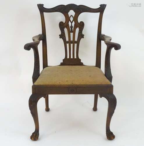 A late 19thC mahogany Chippendale style open armchair, with a carved top rail, back splat and