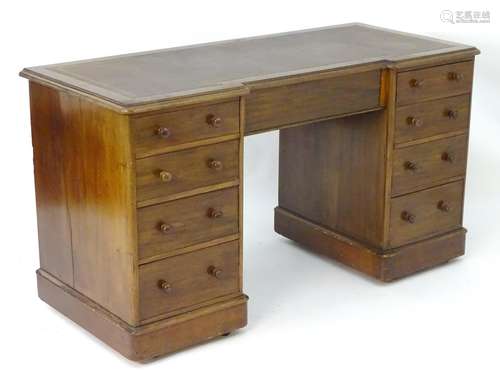 A late 19thC mahogany double pedestal desk with an inverted breakfront top and gold tooled inset