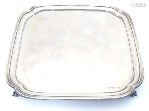 An Art Deco silver salver raised on four acanthus scroll feet. Hallmarked Sheffield 1937 maker