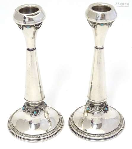 A pair of silver candlesticks with turquoise coloured cabochon decoration. Marked 925 made in