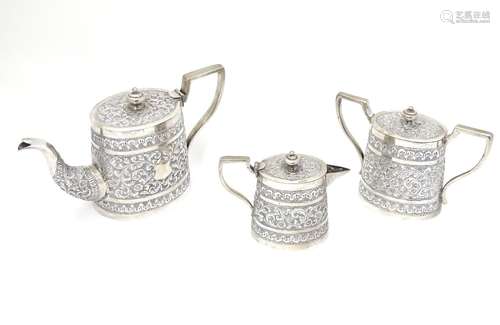 A three piece white metal tea set comprising teapot, lidded milk jug and lidded sugar. with acanthus