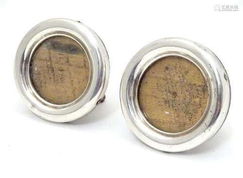 A pair of easel back frames with circular silver surrounds, hallmarked Birmingham 1918, maker Deykin