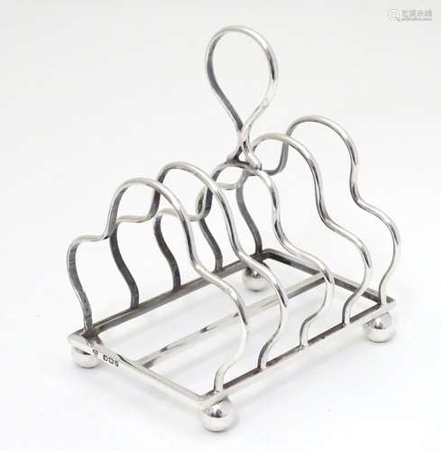 A Victorian silver four division toast rack, hallmarked Sheffield 1893, maker W. W. Harrison & Co.