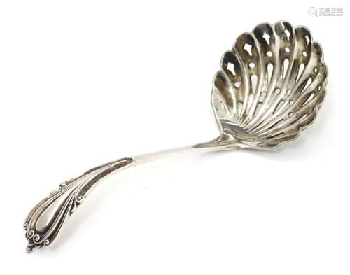 A silver sifting spoon with scallop shell formed bowl, hallmarked Sheffield 1898, maker Cooper