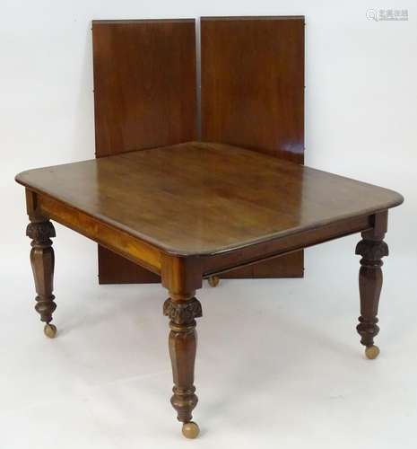 A 19thC mahogany dining table with two additional leaves, rounded corners and standing on canted