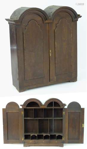 An early / mid 18thC mahogany bookcase with a double domed pediment above two panelled doors. 40