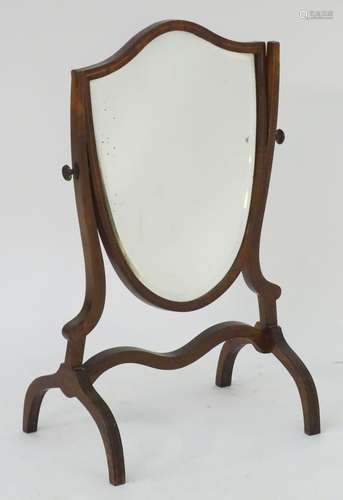 A 19thC shield shaped dressing table mirror with satinwood stringing to the frame, raised on