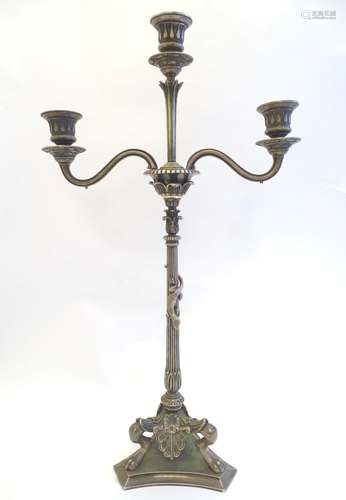 A Victorian silver plate three branch candelabra, with engraved armorial to base, lion's paw feet,