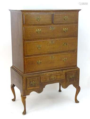 A mid 18thC oak chest on stand, the top having a moulded cornice above two short over three long