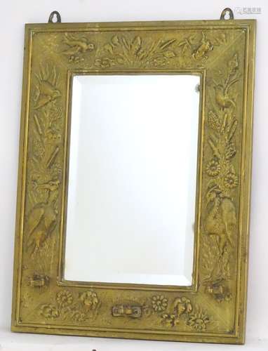 A late 19thC Aesthetic movement mirror / girandole with a brass embossed frame and bevelled edge.