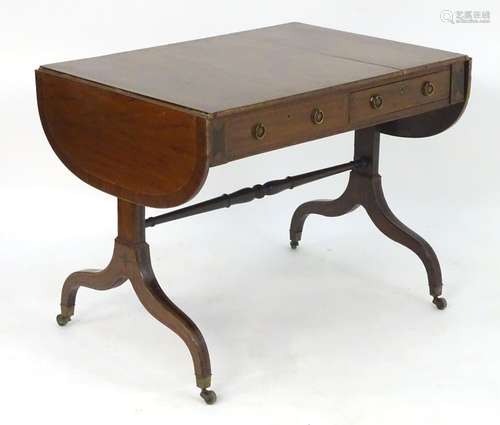 A Regency mahogany sofa table with with drop flaps, with two short drawers and two sham drawers,