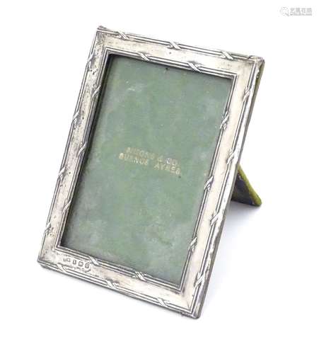 A silver photo frame with crossed ribbon detailing. Hallmarked Birmingham 1913 maker Henry Matthews.