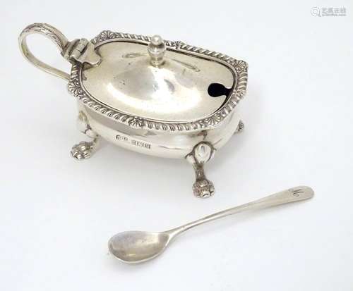 A Silver mustard pot with blue glass liner and associated silver spoon, the mustard pot with