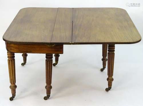 A mid 19thC mahogany extending dining table with a concertina movement and six turned turned