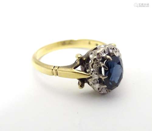 Am 18ct gold ring set with central blue stone bordered by white stones. Ring size approx size N