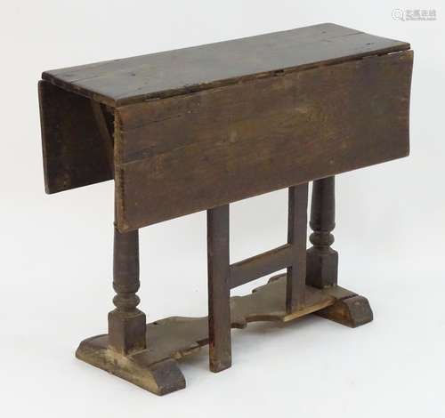 An early / mid 17thC oak gateleg table with a rectangular top above turned tapering supports and a