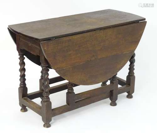 An 18thC oak gateleg table, the drop flaps opening to form an oval table top, the table raised on