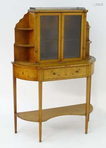 A 19thC satinwood cabinet with a pierced brass gallery above two glazed doors flanked by graduated