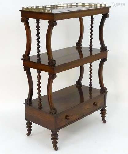 An early 19thC rosewood whatnot with a brass gallery above three tiers with carved and turned