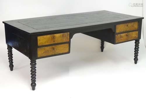 An early 20thC ebonised desk with a rectangular top above four burr walnut fronted drawers, the desk