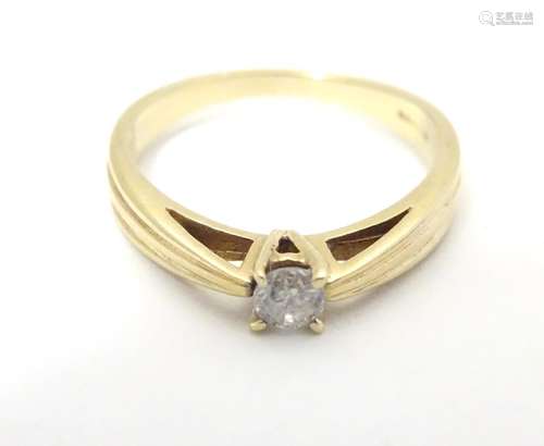 A 9ct gold ring with banded decoration and diamond solitaire. Ring size approx M 1/2 Please Note -