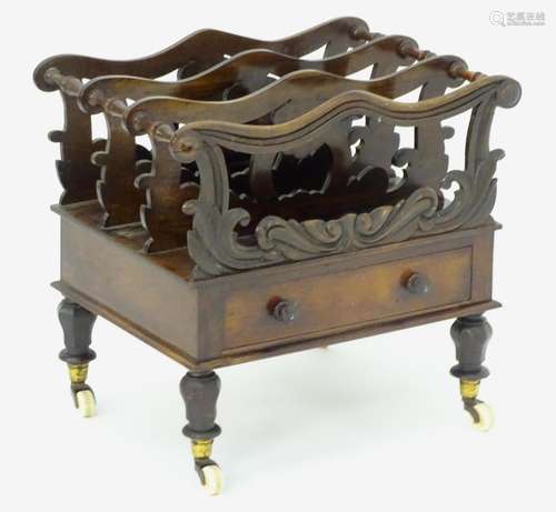 A mid 19thC mahogany canterbury with scrolled and carved dividers with turned supports, having a