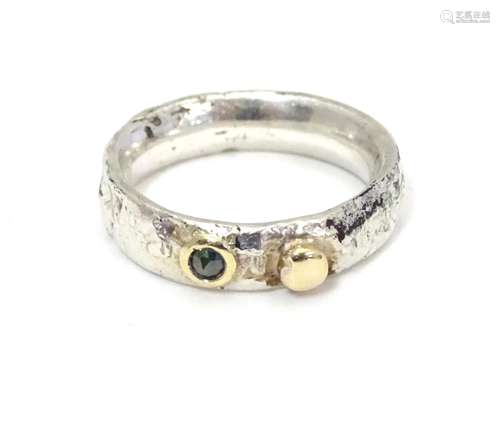 A Contemporary silver ring set with yellow metal and diamond detail. Maker DT . Ring size approx M